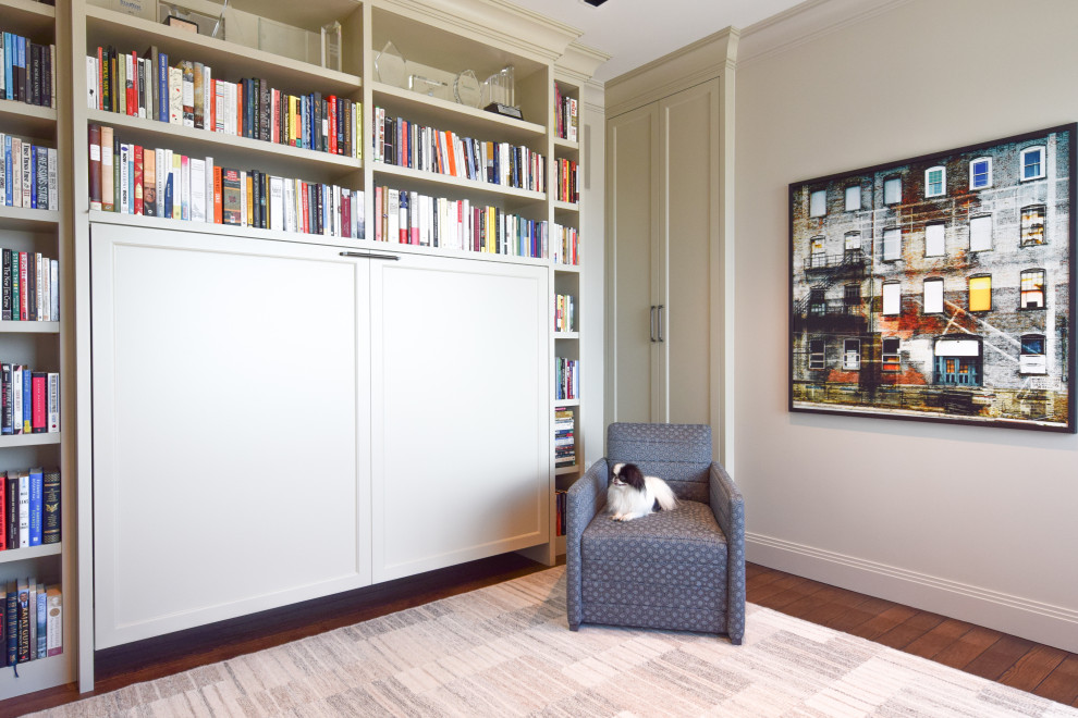 Esempio di un piccolo studio classico con libreria, pareti beige, pavimento in legno massello medio e scrivania autoportante