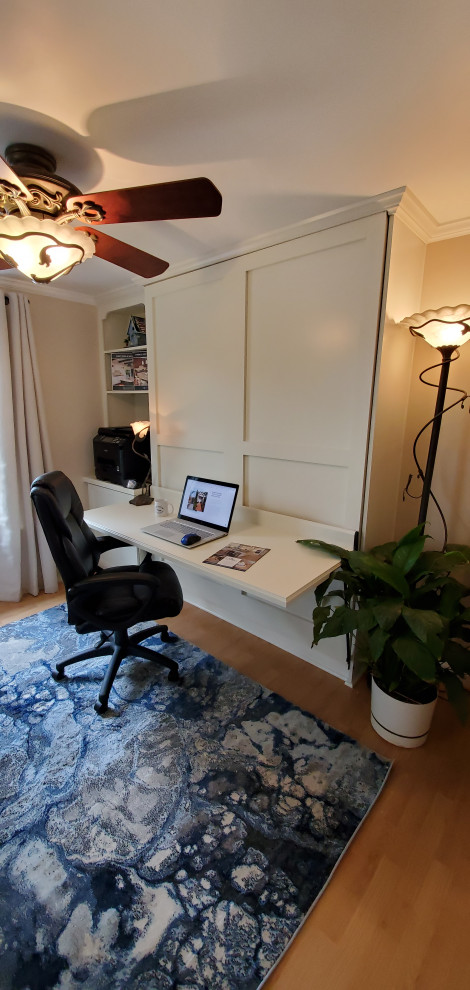 Пример оригинального дизайна: рабочее место среднего размера в современном стиле с бежевыми стенами, полом из ламината, встроенным рабочим столом и коричневым полом