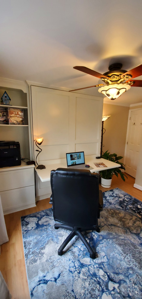 Immagine di un ufficio minimal di medie dimensioni con pareti beige, pavimento in laminato, scrivania incassata e pavimento marrone