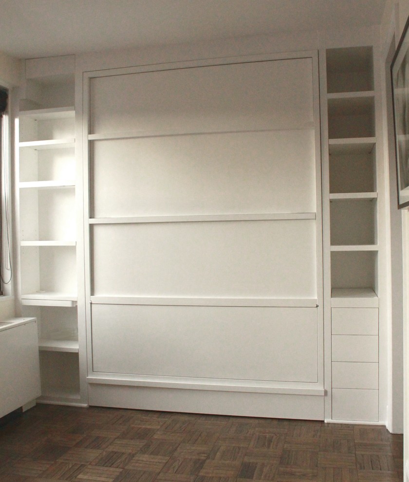 Cette photo montre un bureau tendance de taille moyenne et de type studio avec un mur blanc, un sol en bois brun, aucune cheminée et un bureau intégré.