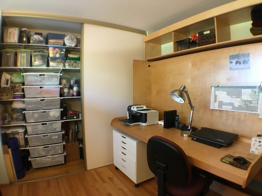 Exemple d'un petit bureau atelier chic avec un sol en bois brun, un mur vert et un bureau intégré.