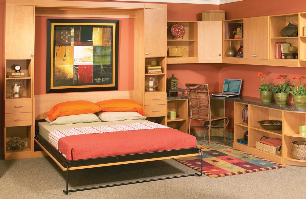 Foto på ett mellanstort amerikanskt hemmabibliotek, med heltäckningsmatta, ett inbyggt skrivbord, beiget golv och orange väggar