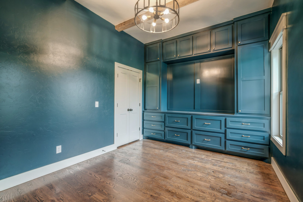 Country Arbeitszimmer mit Arbeitsplatz, grüner Wandfarbe, dunklem Holzboden, Einbau-Schreibtisch und braunem Boden in Oklahoma City