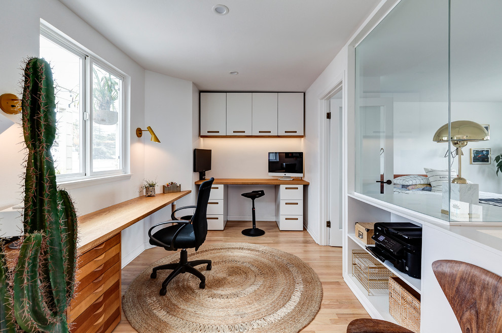 Maritimes Arbeitszimmer mit Arbeitsplatz, weißer Wandfarbe, hellem Holzboden, Einbau-Schreibtisch und beigem Boden in Los Angeles