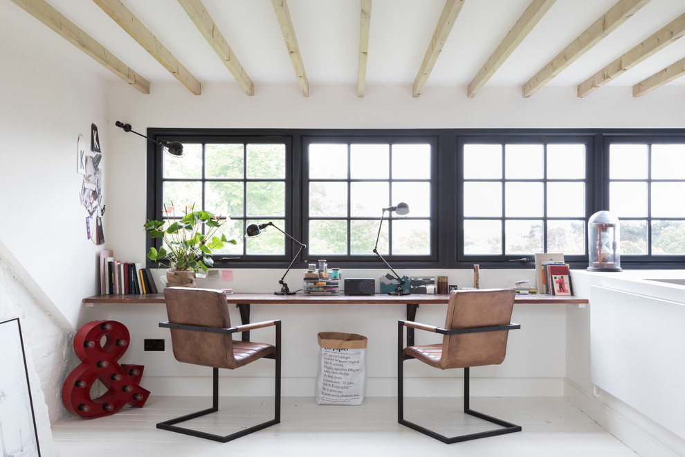 На фото: кабинет в стиле лофт с белыми стенами, деревянным полом, встроенным рабочим столом и белым полом с