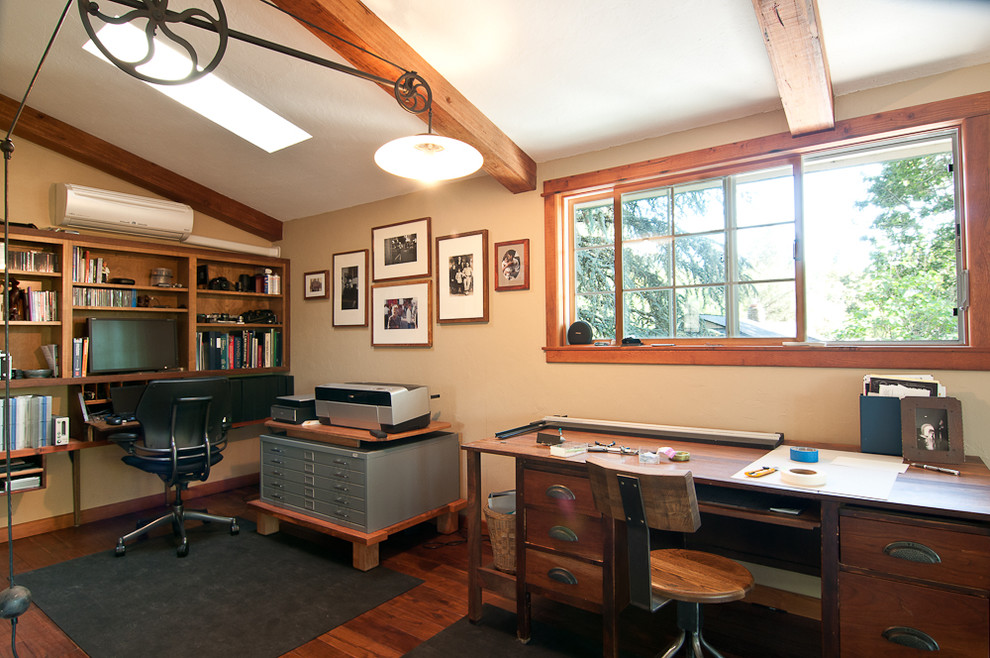 Imagen de despacho clásico con paredes beige, suelo de madera oscura y escritorio independiente