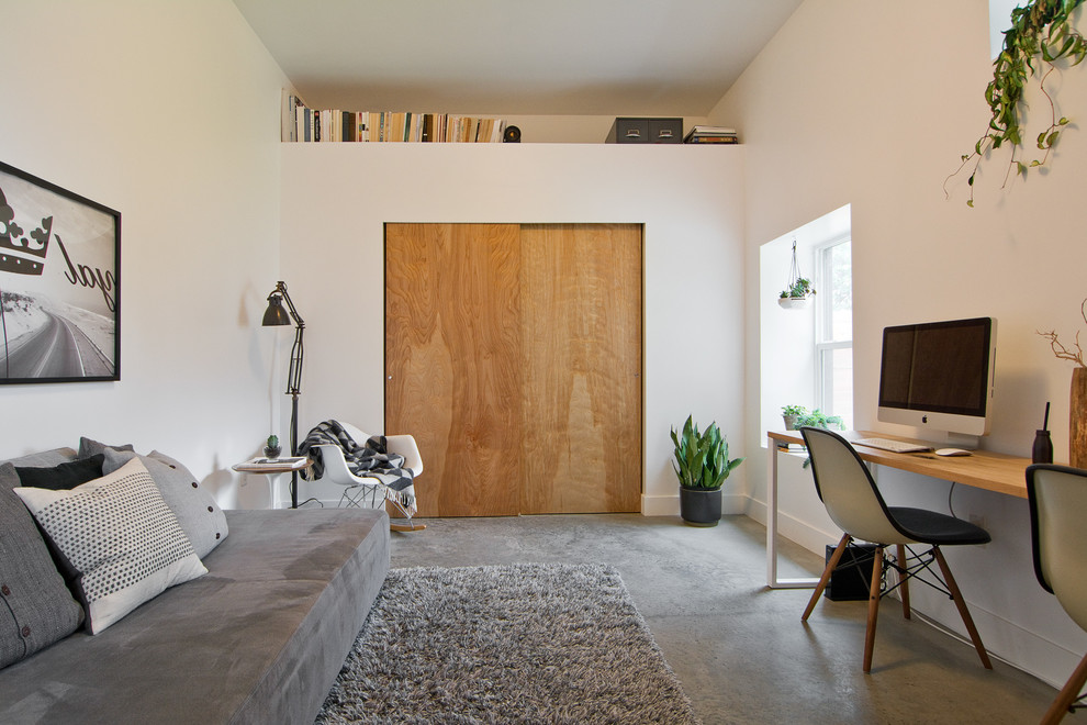 Foto di uno studio minimalista con pavimento in cemento