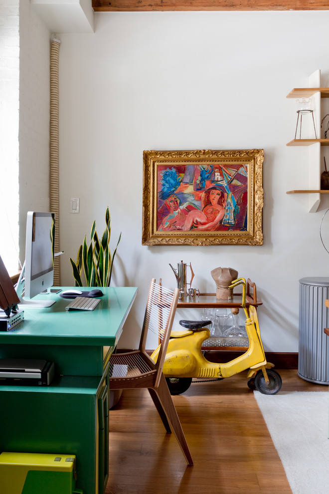 Inspiration for an eclectic freestanding desk medium tone wood floor home office remodel in New York with white walls