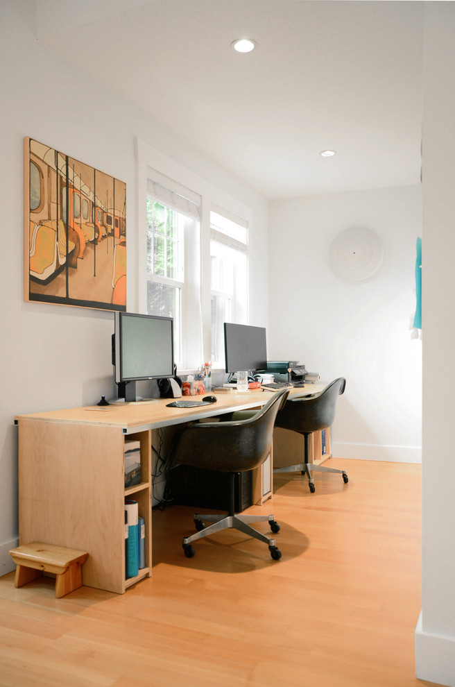Kleines Eklektisches Arbeitszimmer mit Studio, weißer Wandfarbe, braunem Holzboden und freistehendem Schreibtisch in Vancouver