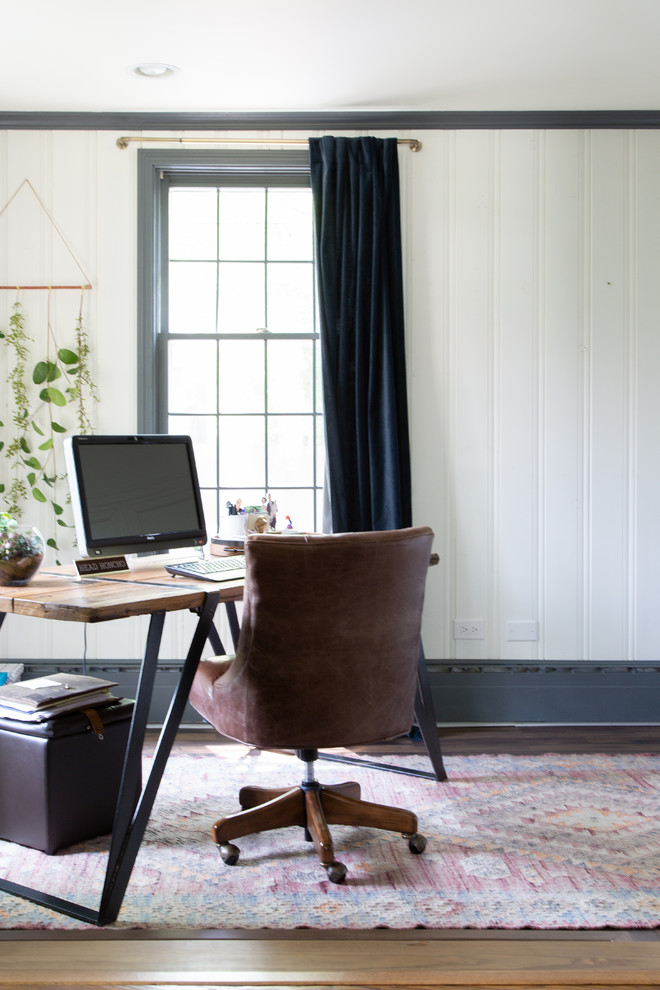 Immagine di uno studio country con pareti bianche, pavimento in legno massello medio, scrivania autoportante e pavimento marrone