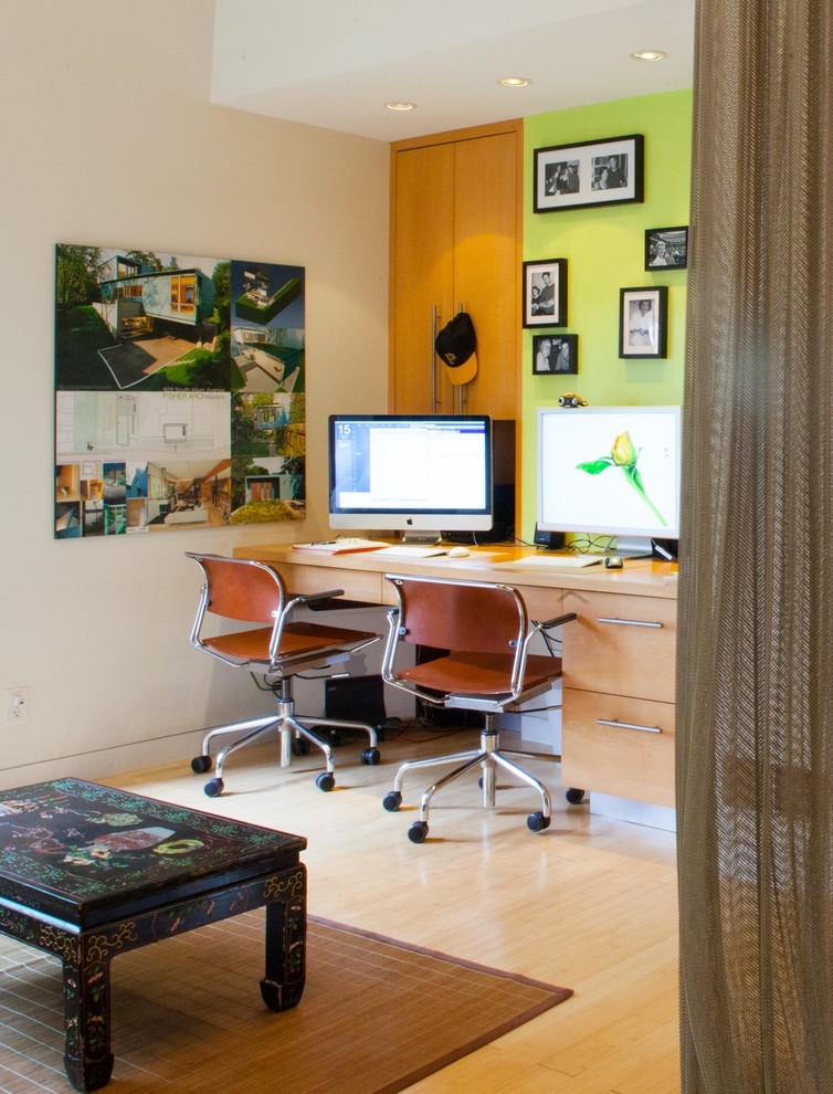 Inspiration for a contemporary home office in Other with green walls, light hardwood flooring and a built-in desk.