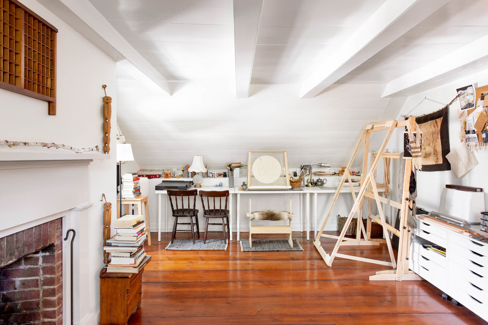 Idee per un atelier country con pareti bianche, parquet scuro, camino classico, scrivania incassata e pavimento marrone