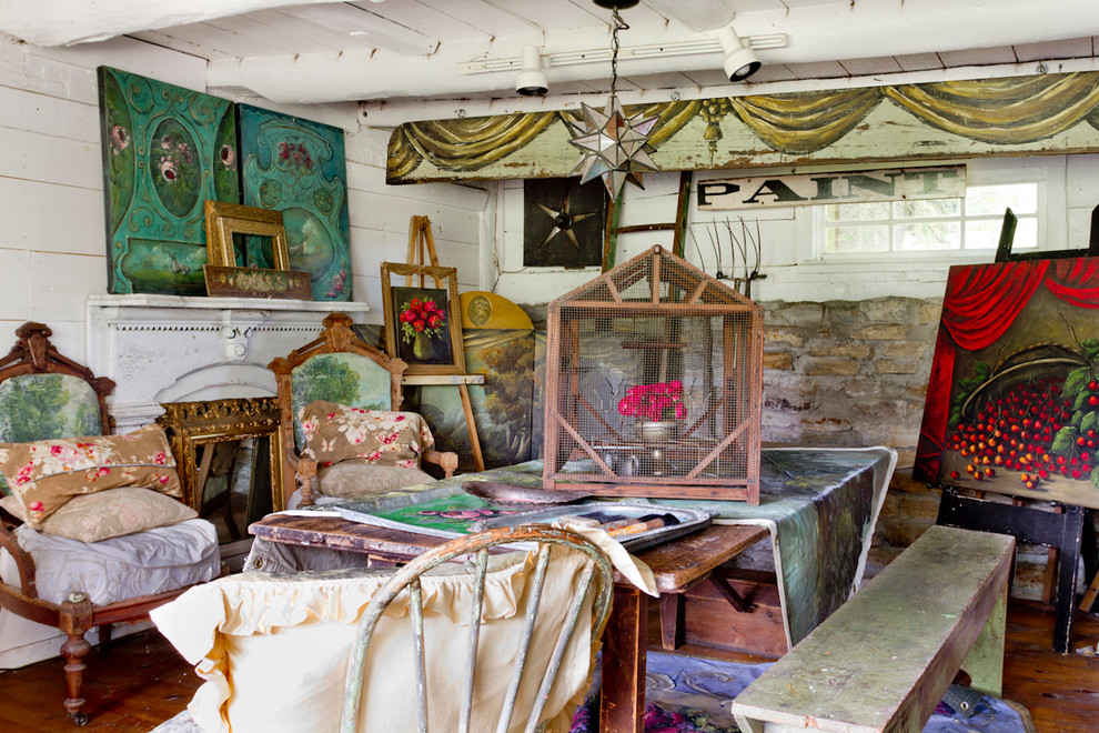 Shabby-Style Arbeitszimmer mit Studio, weißer Wandfarbe, braunem Holzboden, Kamin und freistehendem Schreibtisch in New York