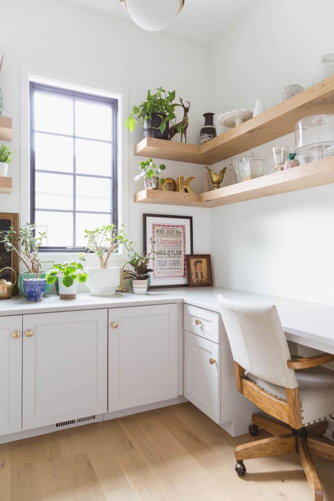 Kleines Skandinavisches Arbeitszimmer ohne Kamin mit weißer Wandfarbe, hellem Holzboden und Einbau-Schreibtisch in Chicago