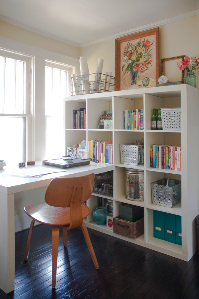 Inspiration för mellanstora eklektiska hemmabibliotek, med beige väggar, mörkt trägolv och ett inbyggt skrivbord
