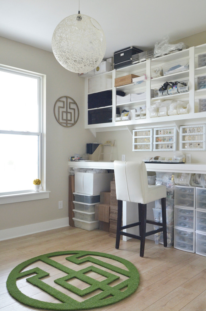 Modern inredning av ett hobbyrum, med grå väggar, ljust trägolv och ett inbyggt skrivbord