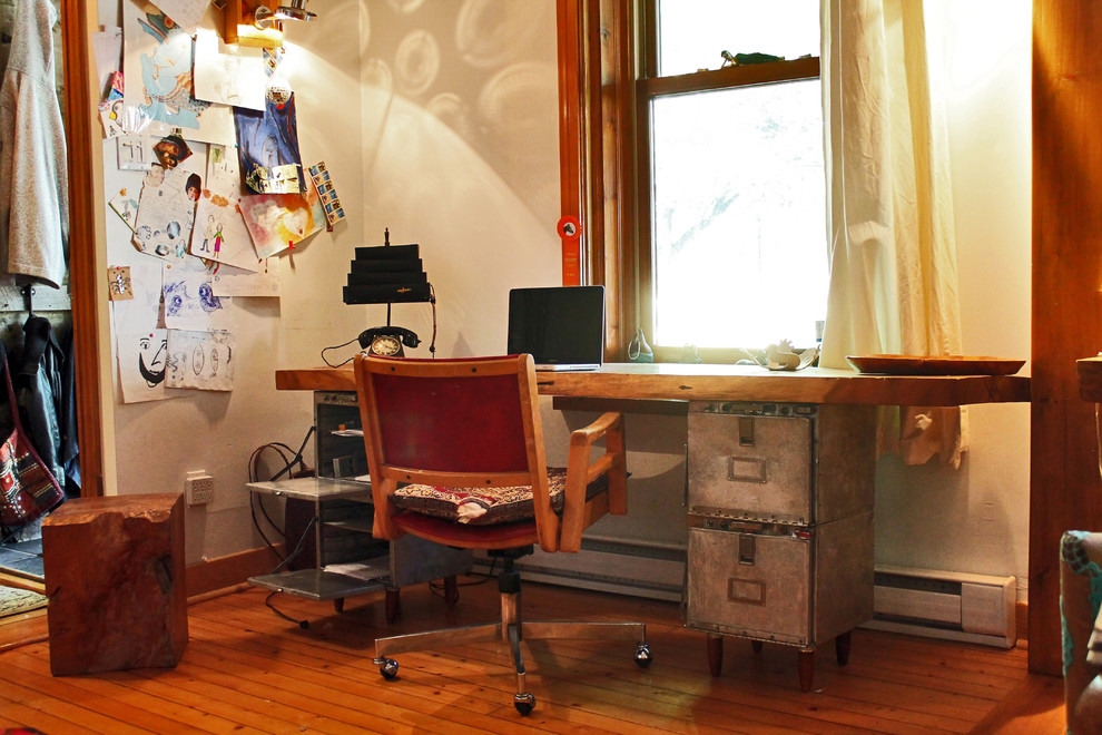 Eclectic freestanding desk medium tone wood floor home office photo in Montreal with beige walls