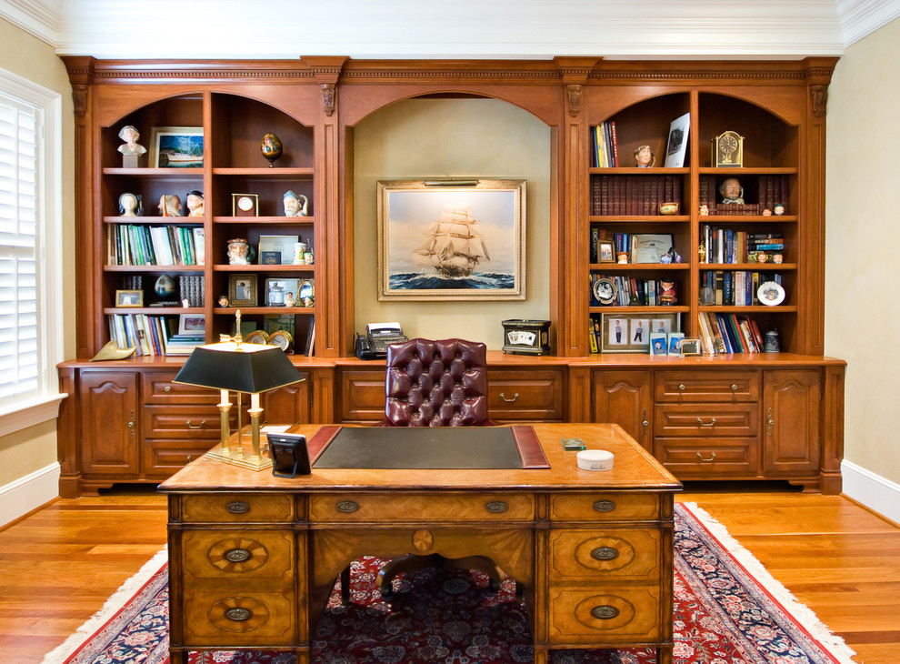 Ejemplo de despacho tradicional con paredes beige, suelo de madera en tonos medios y escritorio independiente