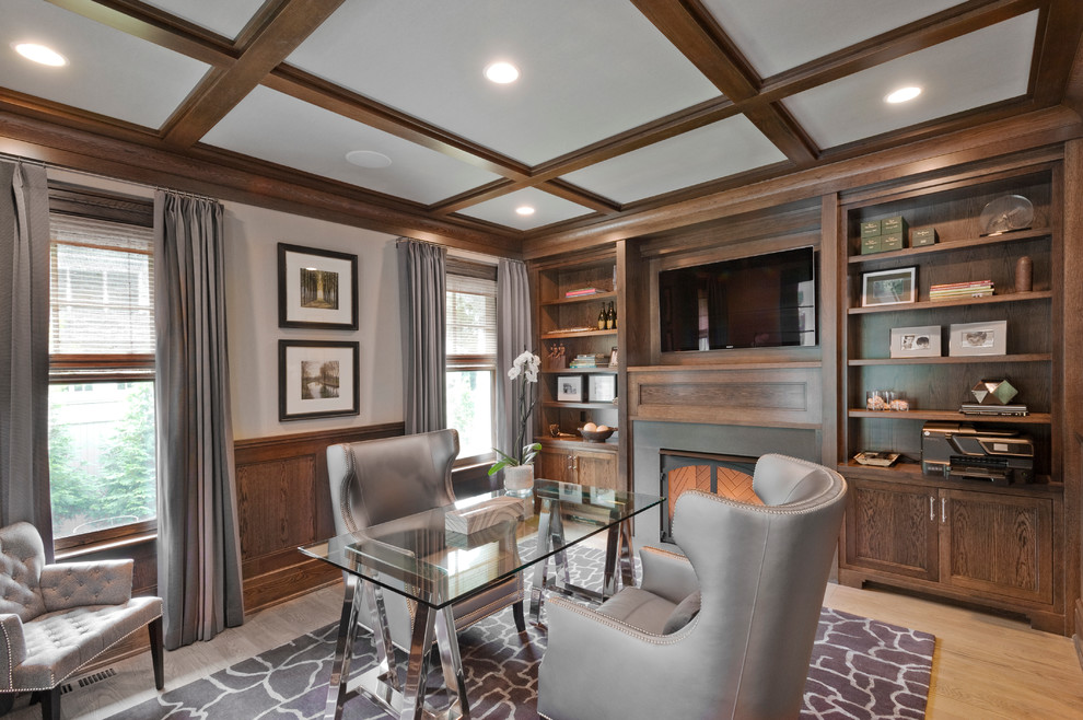 Photo of a medium sized classic study in New York with light hardwood flooring, a standard fireplace, a stone fireplace surround and a freestanding desk.