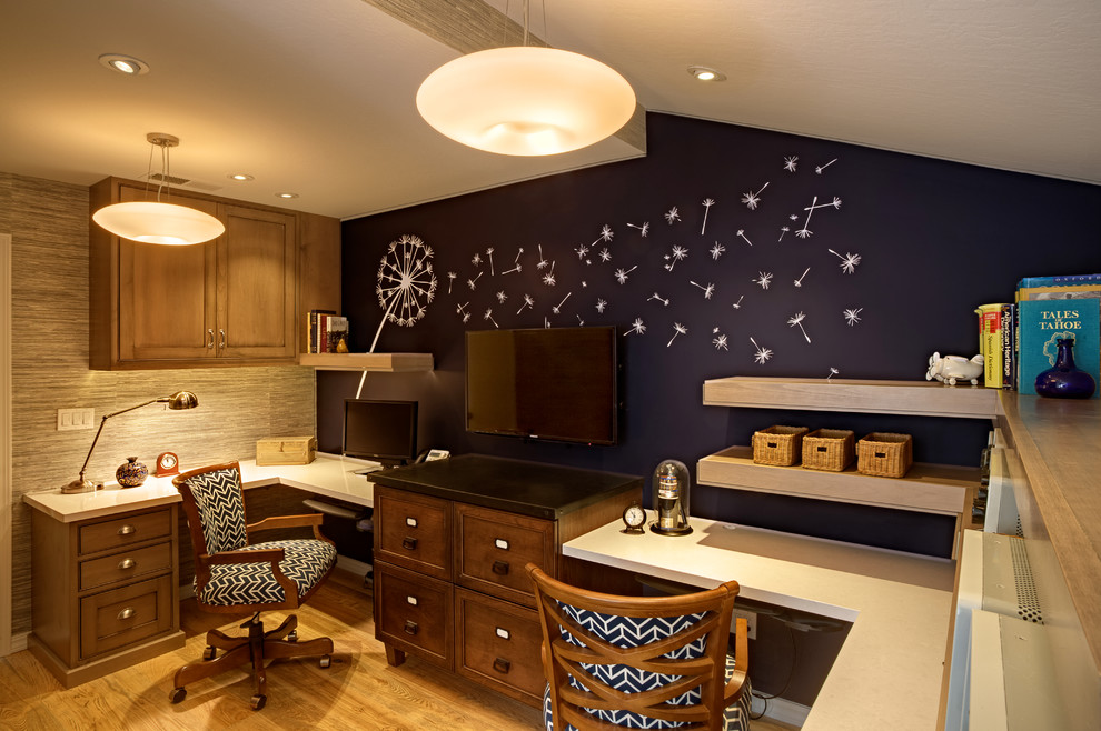 Cette photo montre un petit bureau tendance avec un mur bleu, un sol en bois brun et un bureau intégré.