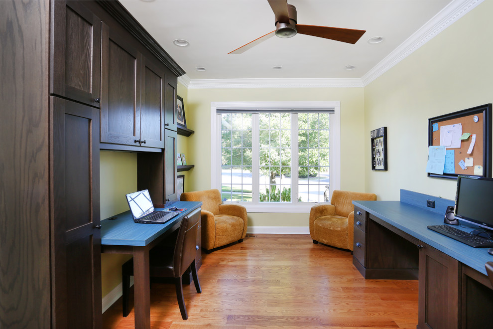 Foto de despacho clásico grande sin chimenea con paredes beige, suelo de madera en tonos medios, escritorio empotrado y suelo marrón