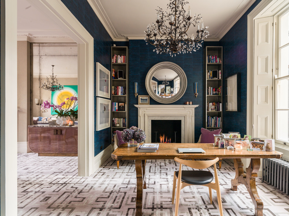 Mittelgroßes Klassisches Arbeitszimmer mit Arbeitsplatz, blauer Wandfarbe, Teppichboden, verputzter Kaminumrandung, freistehendem Schreibtisch und Kamin in London