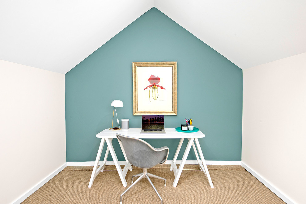 Klassisk inredning av ett litet arbetsrum, med blå väggar, heltäckningsmatta och ett fristående skrivbord