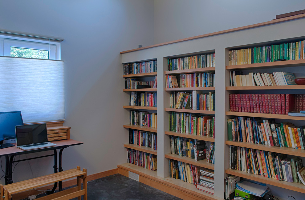 Idéer för ett mellanstort modernt hemmabibliotek, med grå väggar, betonggolv och ett fristående skrivbord