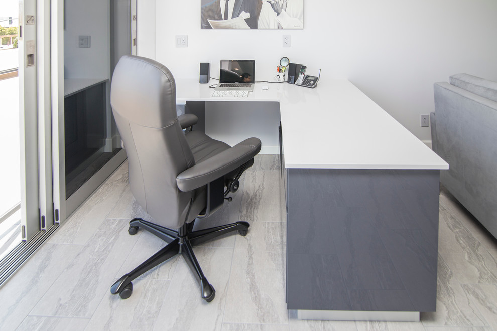 Foto de despacho minimalista de tamaño medio sin chimenea con paredes blancas, suelo de baldosas de porcelana, escritorio independiente y suelo gris