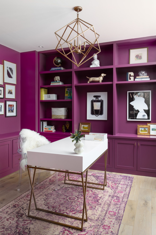 Пример оригинального дизайна: рабочее место в стиле неоклассика (современная классика) с паркетным полом среднего тона, отдельно стоящим рабочим столом, коричневым полом и розовыми стенами