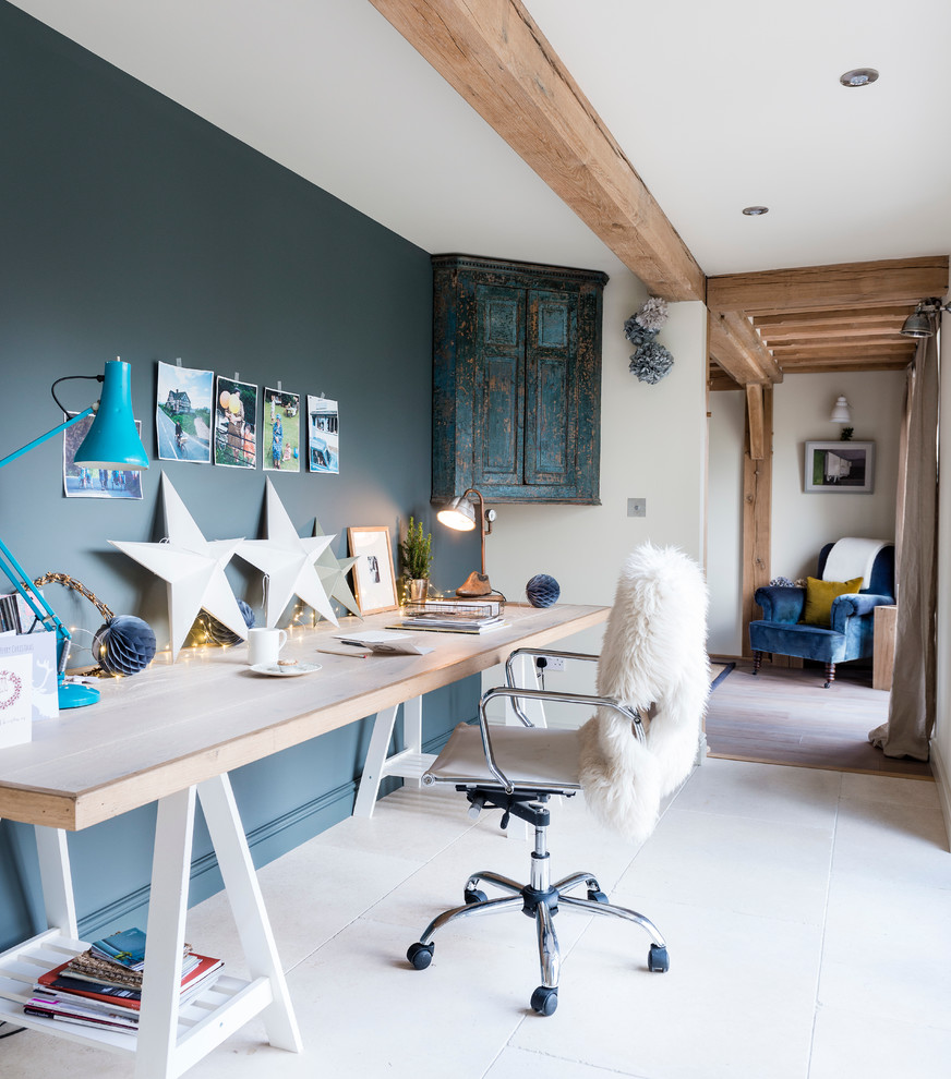 Inspiration för rustika hemmabibliotek, med blå väggar och ett fristående skrivbord
