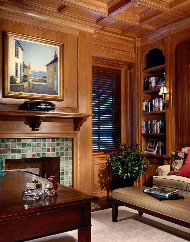 Cette image montre un bureau traditionnel de taille moyenne avec un mur beige, parquet foncé, une cheminée standard, un manteau de cheminée en carrelage, un bureau indépendant et un sol marron.