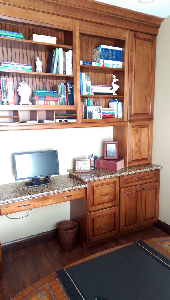 Example of a small classic built-in desk medium tone wood floor and brown floor study room design in St Louis with white walls and no fireplace