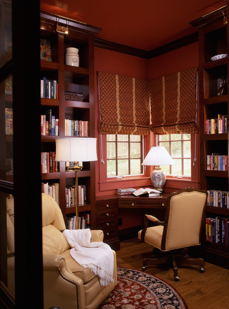 Exemple d'un petit bureau nature avec un mur rouge, un sol en bois brun, aucune cheminée et un bureau intégré.