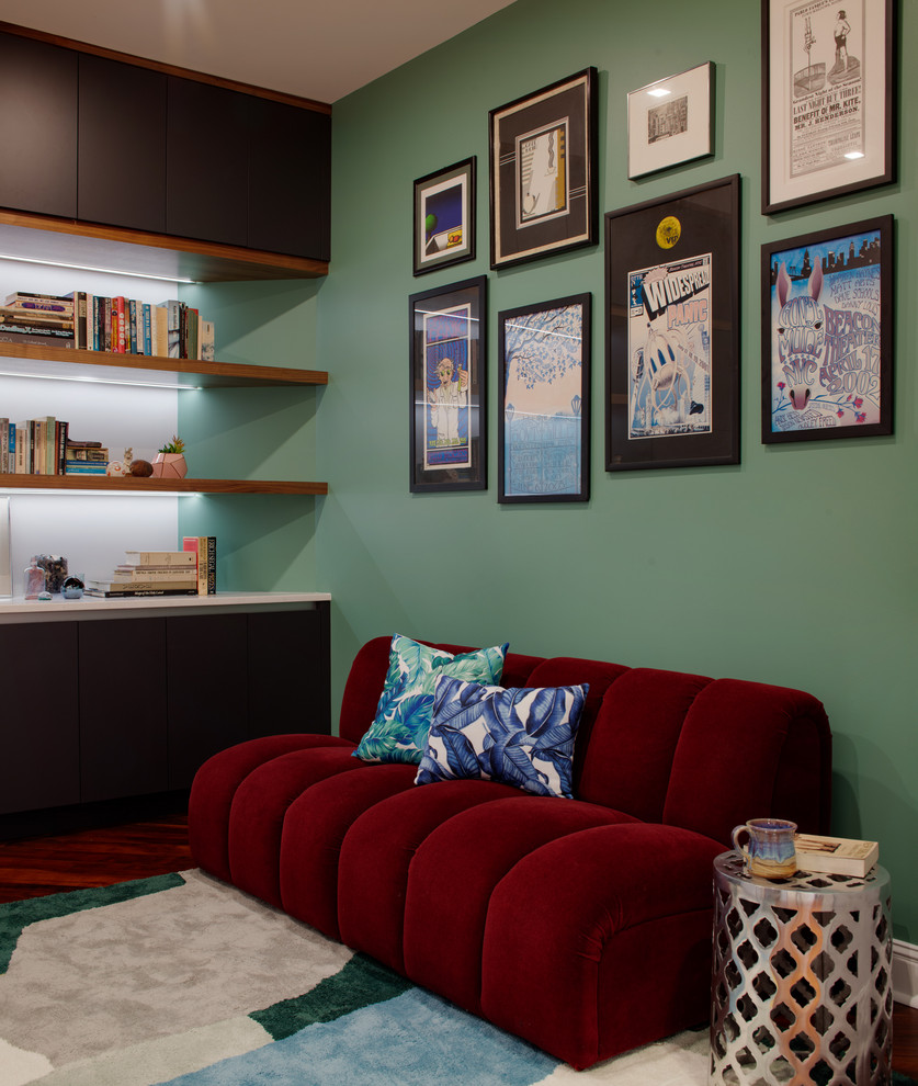 Ejemplo de despacho minimalista grande sin chimenea con biblioteca, paredes verdes, suelo de madera oscura, escritorio independiente y suelo rojo