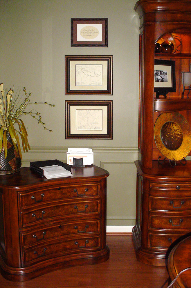 Foto de despacho tradicional de tamaño medio con paredes verdes, suelo de madera en tonos medios, escritorio independiente y suelo marrón