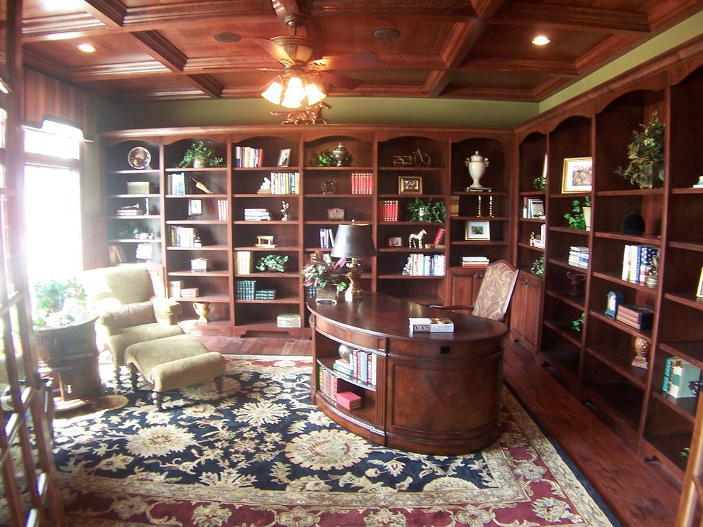 Inspiration för mellanstora klassiska hemmabibliotek, med mörkt trägolv och ett fristående skrivbord