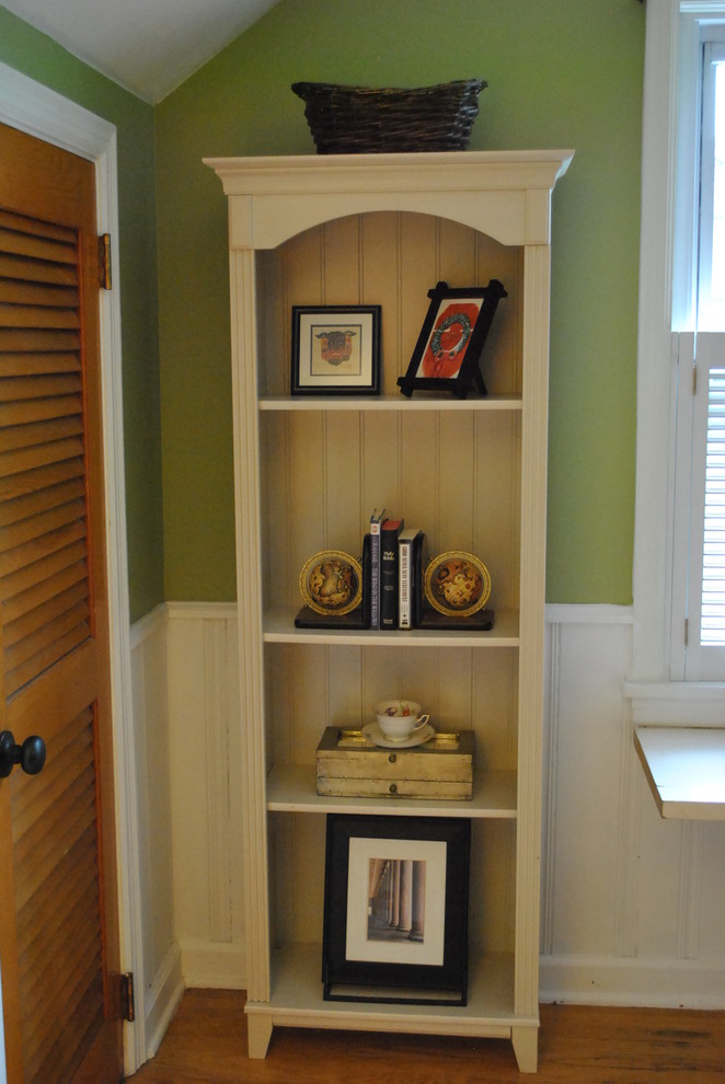 This is an example of a medium sized traditional study in Louisville with green walls, light hardwood flooring and a freestanding desk.