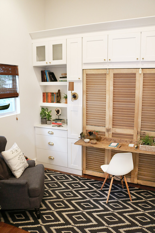 Cette image montre un petit bureau traditionnel avec un mur blanc, un sol en bois brun, aucune cheminée et un bureau intégré.