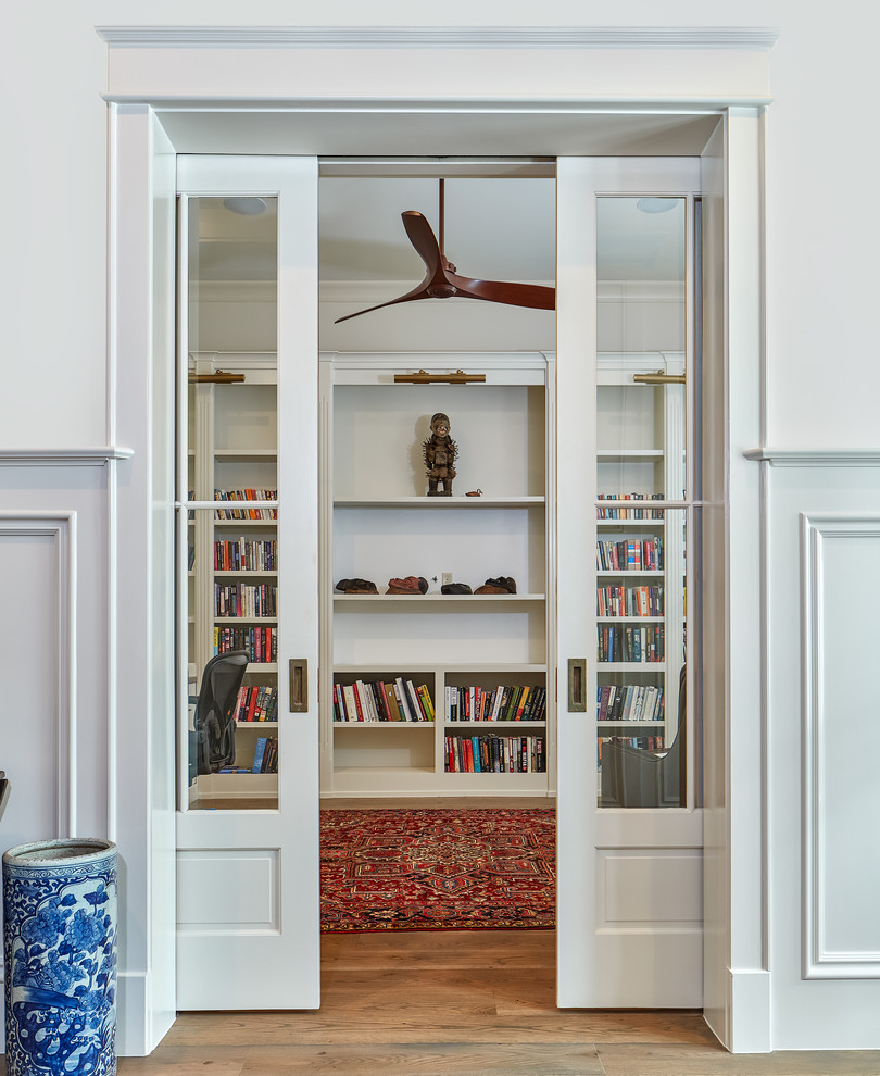 Exemple d'un bureau chic avec une bibliothèque ou un coin lecture, un mur blanc, un sol en bois brun et un bureau indépendant.