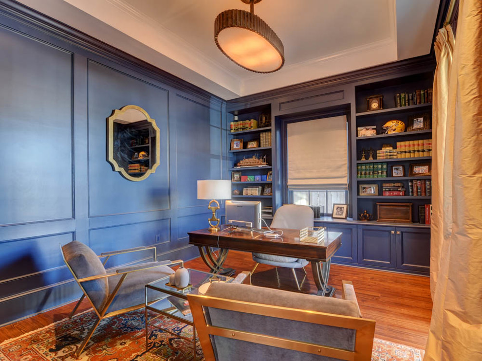 Ispirazione per uno studio tradizionale di medie dimensioni con libreria, pareti blu, pavimento in legno massello medio, nessun camino, scrivania autoportante e pavimento blu