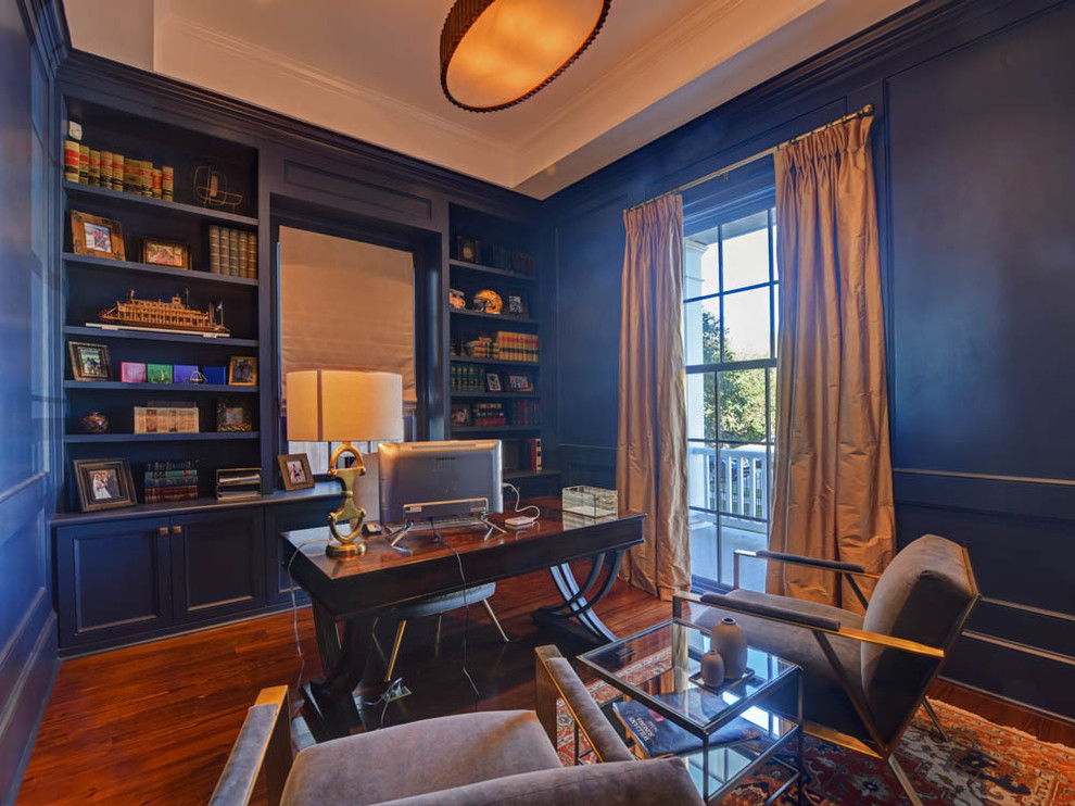 Cette image montre un bureau traditionnel de taille moyenne avec une bibliothèque ou un coin lecture, un mur bleu, un sol en bois brun, aucune cheminée, un bureau indépendant et un sol bleu.