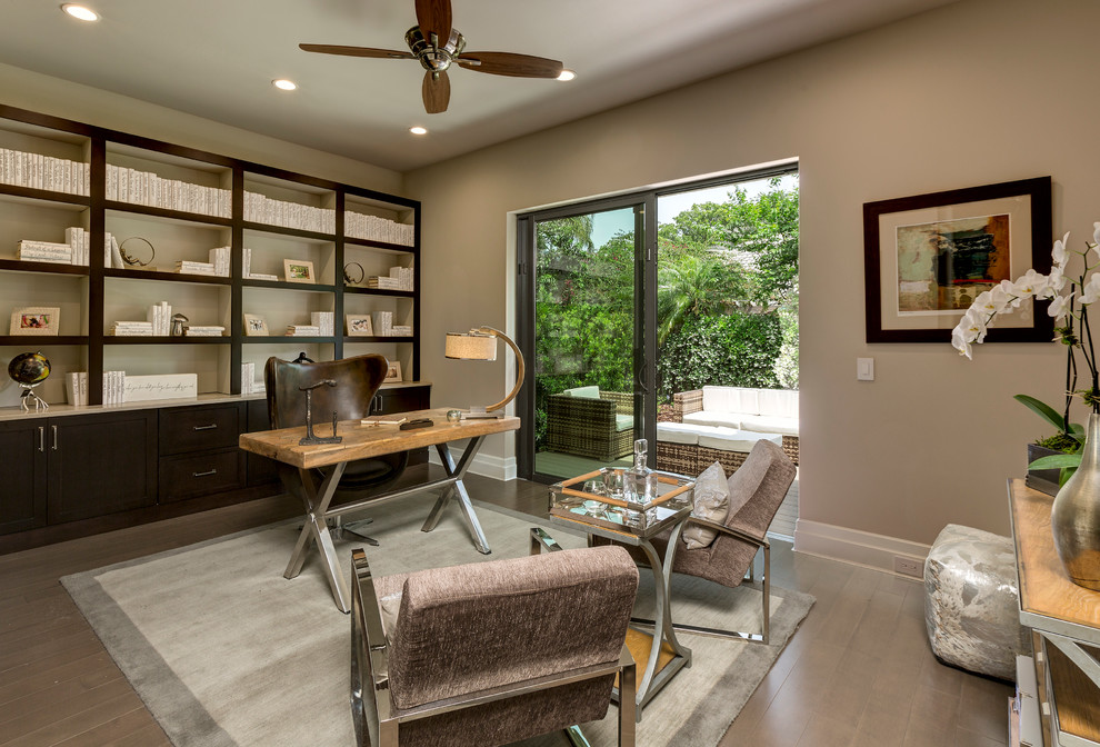 Transitional freestanding desk dark wood floor home office photo in Orlando with beige walls and no fireplace