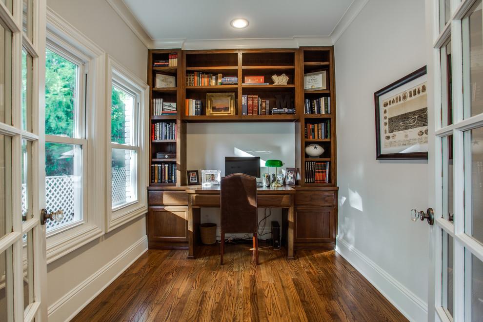 Diseño de despacho tradicional pequeño sin chimenea con paredes blancas, suelo de madera en tonos medios y escritorio empotrado