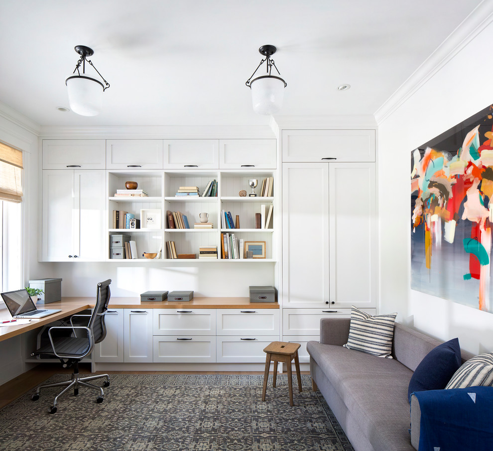 Mid-sized beach style built-in desk medium tone wood floor study room photo in Vancouver with white walls and no fireplace