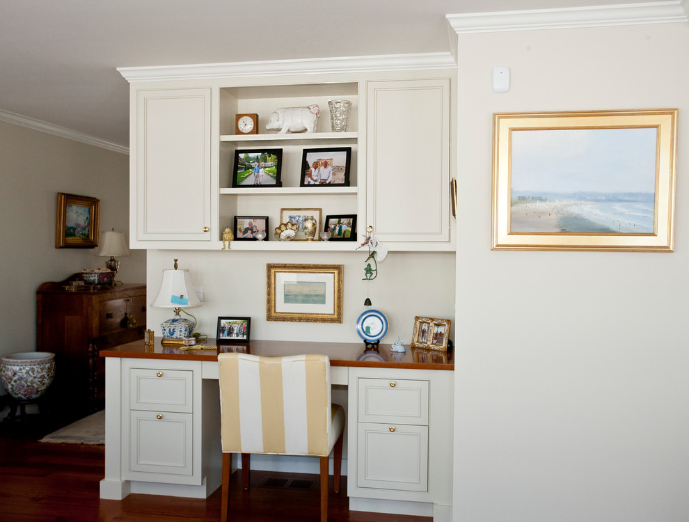 Idées déco pour un bureau classique avec un mur beige, un sol en bois brun et un bureau intégré.