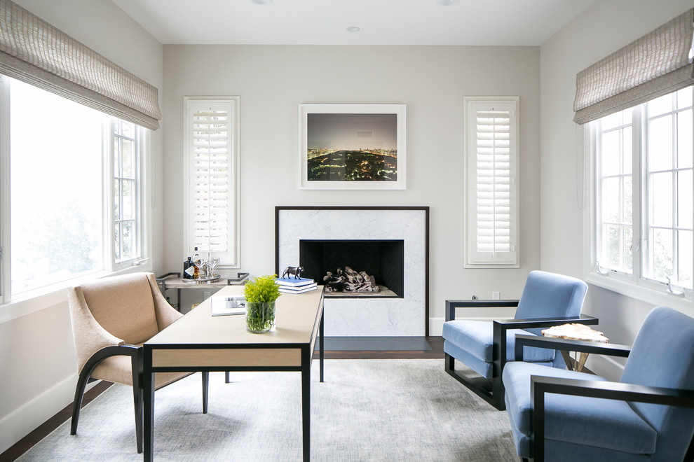 This is an example of a medium sized beach style study in Orange County with grey walls, a stone fireplace surround, a freestanding desk and a ribbon fireplace.