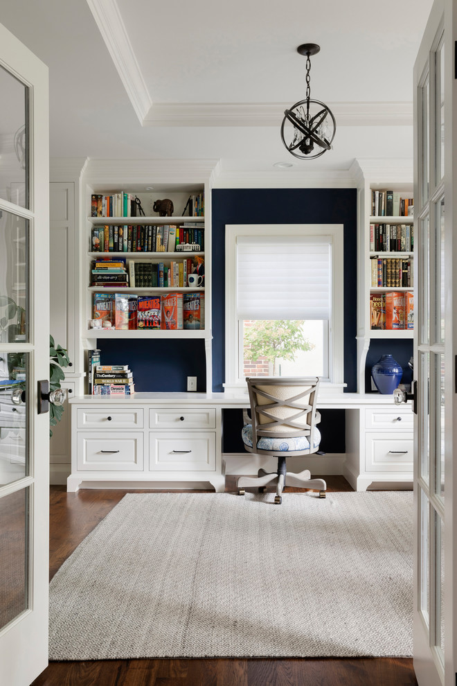 ミネアポリスにあるトラディショナルスタイルのおしゃれな書斎 (白い壁、濃色無垢フローリング、造り付け机、茶色い床) の写真