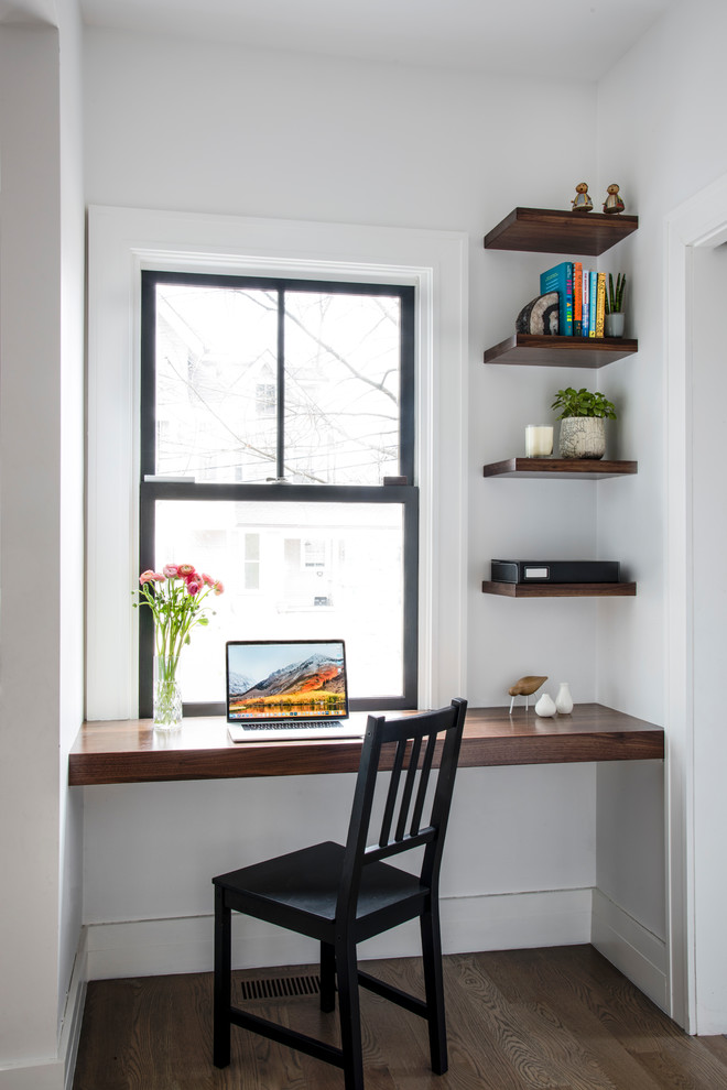 Diseño de despacho contemporáneo con paredes blancas, suelo de madera oscura, escritorio empotrado y suelo marrón