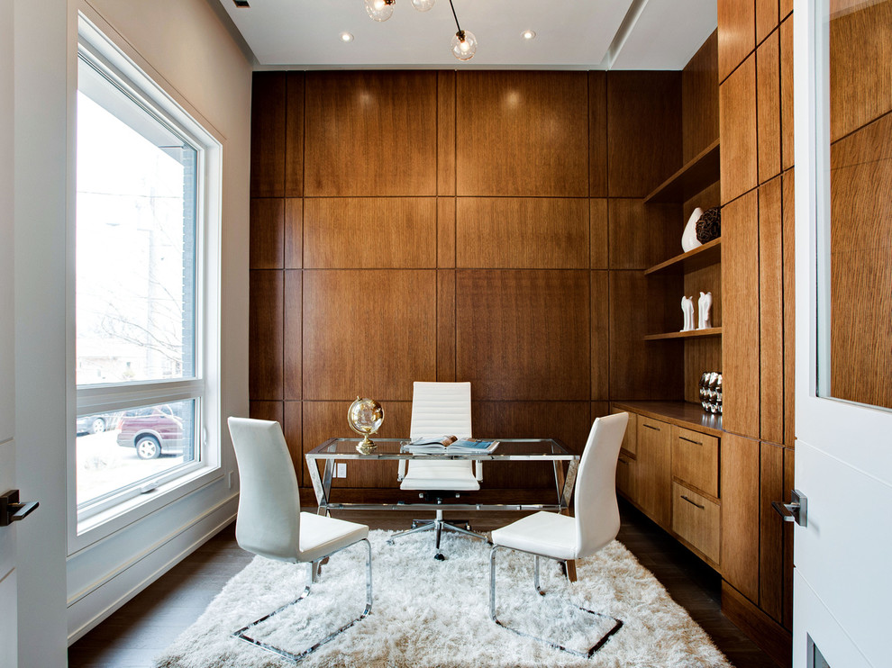 Modernes Arbeitszimmer mit weißer Wandfarbe, dunklem Holzboden, freistehendem Schreibtisch und braunem Boden in Toronto